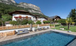 una casa con piscina frente a una montaña en Apartments Schmalzerhof - Eppan an der Weinstraße, en Appiano sulla Strada del Vino
