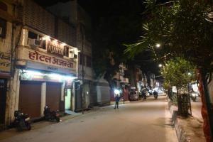 a city street at night with motorcycles parked on the street at Hotel Ajanta Rekabganj Faizabad Ayodhya in Jāmb +37 photos