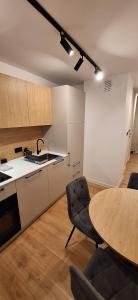 a kitchen and a table in a kitchen with a table and chairs at Apartament Barska Faktura vat in Nowy Sącz