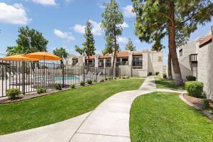 ein Gehweg vor einem Haus mit einem Zaun in der Unterkunft Landing Apartments Phoenix - Maryvale Village in Phoenix