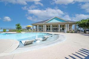 a swimming pool with chairs and a building at Landing Apartments Austin - Lockhart in Lockhart