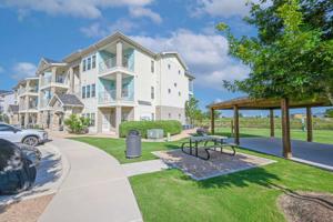 a house with a picnic table in front of it at Landing Apartments Austin - Lockhart in Lockhart