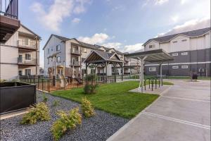 a park with a playground in front of a building at Landing Apartments - Woodburn in Woodburn