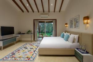 a bedroom with a large bed and a television at Lamrin Morjim Goa in Morjim