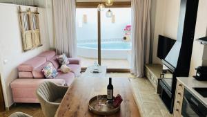 a living room with a couch and a table with a bottle of wine at Al Zahra Suites in Zahara de la Sierra