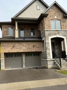 a house with two garage doors and a balcony at masters bet room in Whitby