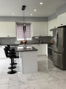 a kitchen with white cabinets and stainless steel appliances at masters bet room in Whitby