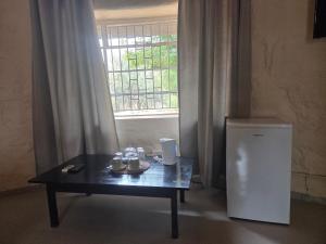 a table in front of a window with a small refrigerator at Three Bridges B&B in Hoedspruit