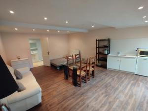 a living room with a couch and a table and a kitchen at Studio A côté Du Plus Beau Marché De France in Béziers