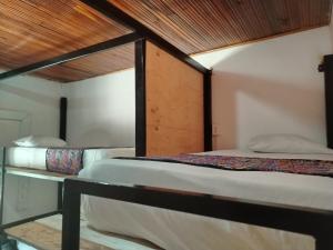 two bunk beds in a room with a wooden ceiling at Backpackers And Travellers Hostel in Neiva
