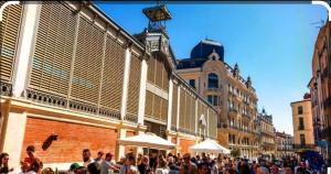 a crowd of people walking down a city street at Studio A côté Du Plus Beau Marché De France in Béziers