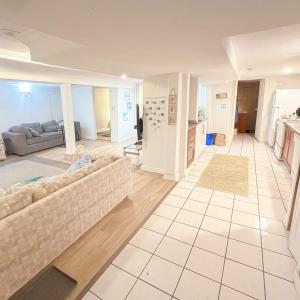 Oak BayにあるMelrose Place Poolside Hideaway Basement Suite Sleeps 6 plusのソファとキッチンのあるリビングルーム