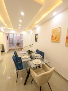 ラ・ロマーナにあるEncanto Luxury Stay - Romana del Oesteのダイニングルーム(ガラステーブル、青い椅子付)