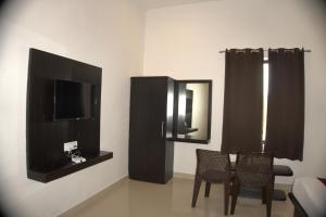 una camera con due sedie, una TV e uno specchio di The Ashok Heritage Resort & Retreat a Pushkar