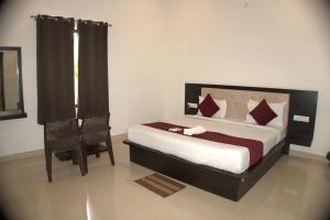 una camera da letto con un letto e una sedia di The Ashok Heritage Resort & Retreat a Pushkar Altre 22 foto