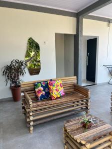 a wooden bench with pillows in a room at Suítes Preguiça in Sao Jorge