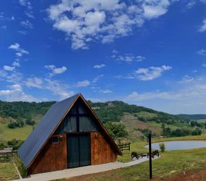 a barn with horses in a field and a lake at Sky chalé - Refúgio Da Lua in Ametista do Sul