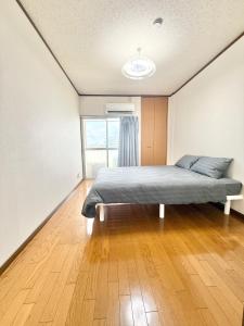 a bedroom with a bed and a large window at 折尾Inホテル305 in Kitakyushu