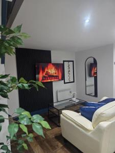 a living room with a white couch and a fireplace at The Nook Free Parking Short way City Centre in Hull