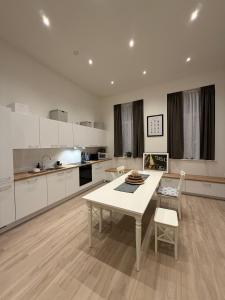 a white kitchen with a table and chairs in it at The Gallery Saint-Gilles in Brussels