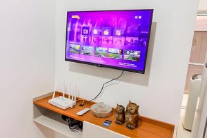 a flat screen tv hanging on a wall at Apartamento com piscina, arcondicionado e vaga in Ourinhos