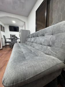 ein großes Sofa im Wohnzimmer mit einem Tisch in der Unterkunft Nice apartment near the bay, Los Cocos beach - Lindo apartamento cerca a la bahia, playa los cocos in Santa Marta