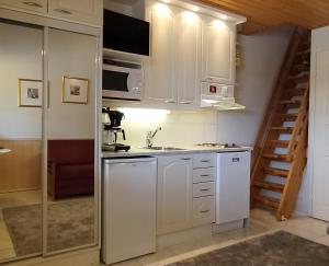 a kitchen with white cabinets and a sink at Ruska Levi - Cozy Apartment in the Center in Levi +16 photos
