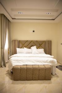 a bedroom with a large bed with white sheets and pillows at Maa Lagos in Mama