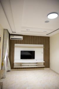 a living room with a flat screen tv on a wall at Maa Lagos in Mama