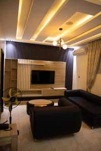 a living room with a couch and a tv at Maa Lagos in Mama