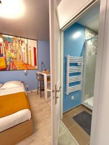 a small bedroom with a bed and a shower at Plein centre-ville refait à neuf avec parking gratuit - Studio Lisbonne in Châtellerault