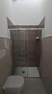 a bathroom with a toilet and a glass shower at Casetta Giardinetto in Altavilla Milicia +37 photos