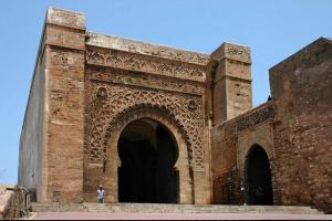 uma pessoa em pé em frente a um grande edifício de tijolos em Stay in Rabat with local em Rabat