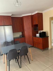 a kitchen with a table and chairs and cabinets at The Comfort Cottage in Saulspoort +6 photos
