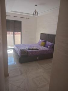 a bedroom with a bed with purple sheets and pillows at Your best Room to stay near casablanca airport in Deroua