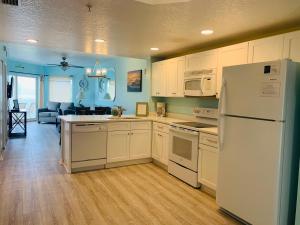 a kitchen with white cabinets and a white refrigerator at Winter Sale on Now-Sunset Vistas 303N 100s 5 stars in St Pete Beach