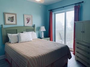 a bedroom with a bed with blue walls and a window at Winter Sale on Now-Sunset Vistas 303N 100s 5 stars in St Pete Beach +20 photos