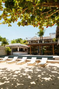 a group of lounge chairs sitting in front of a building at Villa Praia - La Villa Group in Jericoacoara