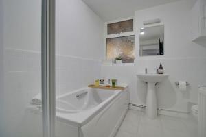 a white bathroom with a sink and a shower at Stylish spacious apartment near airport, Rawdon in Rawdon
