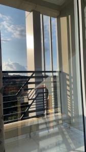 una persona de pie en un balcón con vistas por la ventana en travelers' house, en Yaoundé