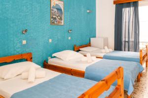 a room with three beds with blue walls at Dilino in Kamari