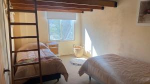 a bedroom with a bunk bed and a window at La Casona Dique Chico in Villa Anizacate