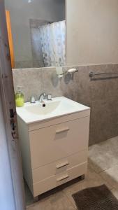 a bathroom with a white sink and a mirror at La Casona Dique Chico in Villa Anizacate