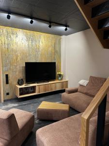 a living room with a flat screen tv on a wall at Dom w Czerwonej Dolinie Haus im Roten Tal Seidorf Sosnówka` in Sosnówka