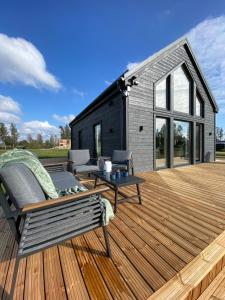 a wooden deck with a black house at REAL House 