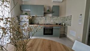 a kitchen with green cabinets and a wooden table at Casetta Giardinetto in Altavilla Milicia