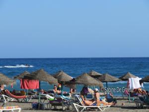 eine Gruppe von Menschen am Strand mit Sonnenschirmen in der Unterkunft Primera línea de playa, deditos de los pies en la arena !! Carabela-C704 Piscina Torrox-Costa in Torrox Costa + 44 Fotos