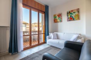 un soggiorno con un divano e una grande finestra di Palladio Retreat Flat, best comfort in Vicenza a Vicenza
