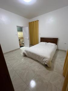una camera da letto con un letto bianco in una stanza di Grande Maison Familiale Vue Mer et Montagne a D'Epinay