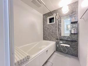 a white bathroom with a tub and a shower at Spacious Cozy house in Shinjuku Free parking wifi in Tokyo +57 photos